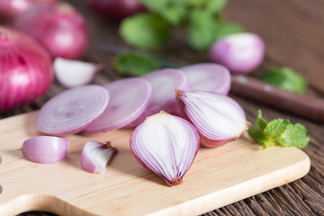 Sliced of red onion on wood board.