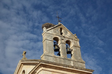 Nido de cigueña sobre la torre del campanario de una iglesia