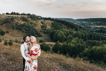 Walking A loving couple against the background of the mountains at sunset. Love story. Gentle embrace