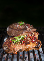 Beef steaks on the grill with flames