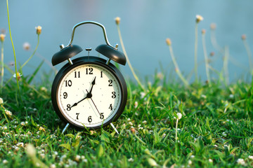 Black alarm clock on nature background with copy space
