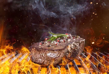 Crédence de cuisine en verre imprimé Grill / Barbecue Steak de boeuf sur le gril avec des flammes