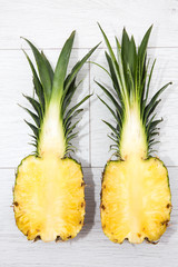 Looking down from above onto a fresh pineapple sliced into two halves showing a cross section