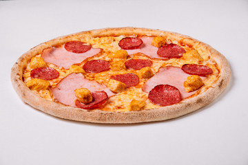 Pizza with salami, chicken and ham isolated on white