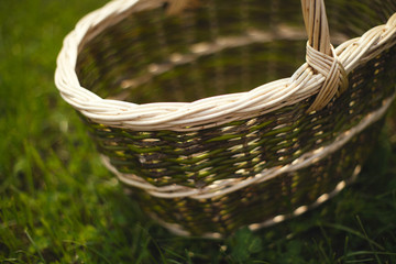 Obraz premium Wicker basket stands on a background of green grass. Tilt-shift effect.