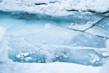 Large blue cracked ice surface on the river.