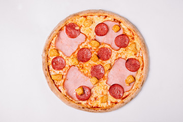 Pizza with salami, chicken and ham isolated on white. Top view