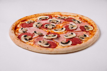 Pizza with salami ham and mushrooms isolated on white