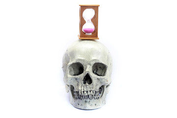 The skull of a dead man with an hourglass at the time of life is over on isolated white background