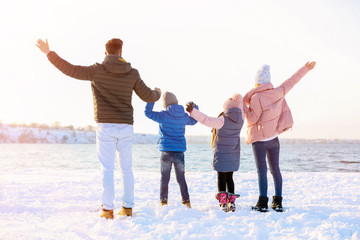 Obraz premium Happy family near river on winter day
