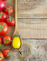 Fresh red and yellow tomatoes on wooden background