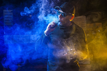 Vape man.  A man lets out steam from an electronic cigarette. An alternative to cigarettes. A man...