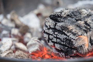 Hot charcoal burns in the grill with embers