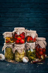 Pickled foods in cans. Stocks of food. Top view. On a wooden background. Copy space.