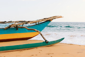 Close-up Sri-Lanka fishing boat on the ocean Narigama beach. Traditional blue-yellow wooden painted ship.