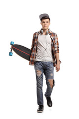 Teenage skater with a longboard walking towards the camera