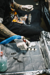 Master tattooing a back woman