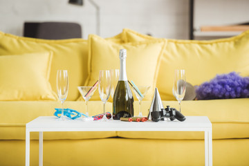 closeup shot of table with champagne, glasses, joystick and party supplies
