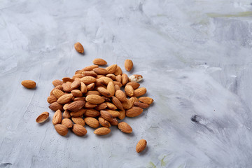A pile of shelled almond nuts isolated against white background, close-up, top view, selective...