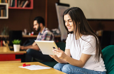 Obraz premium Young girl enterpreneur work with tablet in modern office