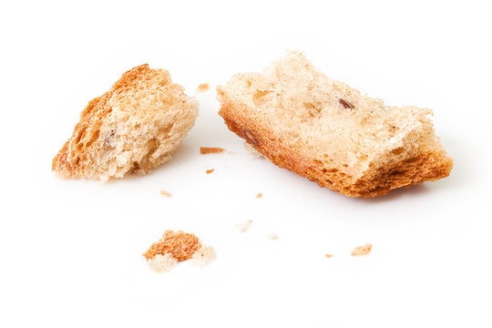 Bread crumbs isolated on white background. Pieces of dry bread for birds on white background. Detail of small bread pieces, fodder for birds on white backdrop. Macro photography, closeup shot.
