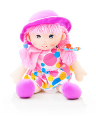 Cute rag baby doll sitting on white underlay. Isolated on white background with shadow reflection. Nice contemporary rag baby with pink hair, violet hat and speckled clothes. Modern joyfully rag baby