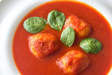 Portion of tomato soup with meatballs
