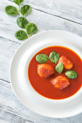 Portion of tomato soup with meatballs