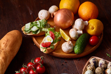 Breakfast still life with sandwiches, quail eggs, spicies and fresh fruits and vegetables, selective focus