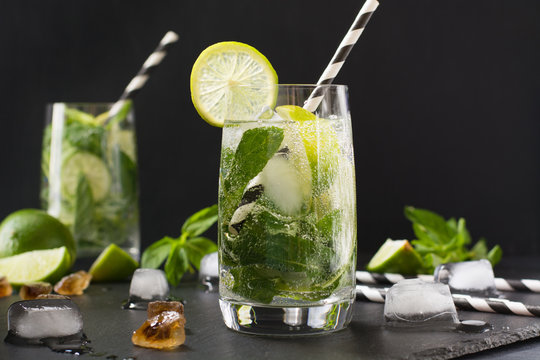 Mojito cocktail in glass on black table. Low key photo. Close up.