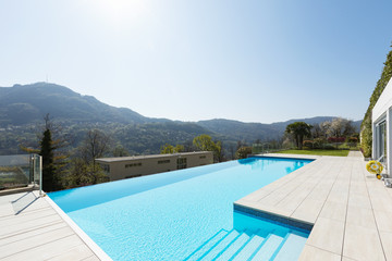 Exterior of building with swimming pool overlooking the hills