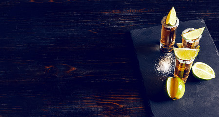 three glasses of tequila and pieces of lime