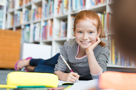 Girl lying on floor writing