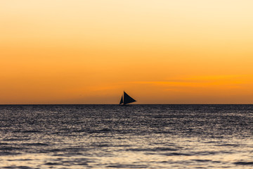 Obraz na płótnie Canvas One outrigger sailboat on the horizon