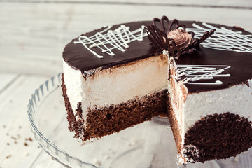 dark chocolate vegan cake with cream on wooden background