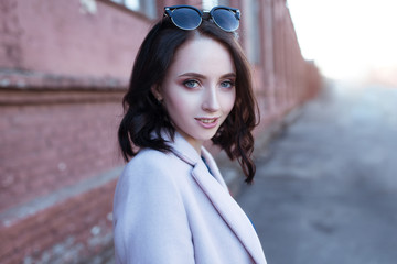 Portrait of young beautiful smiling girl with brown hair in the city.