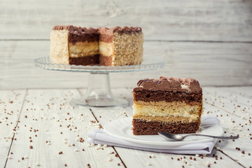 dark chocolate vegan cake with cream and caramel on wooden background