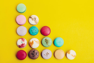 Tasty different colored macarons  on yellow background   