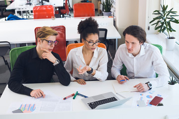 Anyone who is willing to work and is serious about it will certainly find a job! Young smart people thinking over their new business startup, while using the laptop.