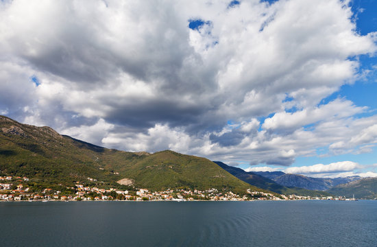 Montenegro. The coast of Kotor Bay. View from the sea to the town of Bijela and beautiful clouds over the mountains