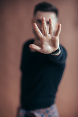 Portrait of young man doing stop symbol