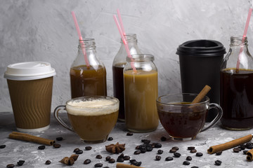 various of  coffee drinks in different cups and bottles concrete background