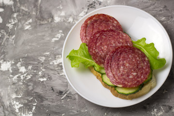 top view fresh sandwich with smoked sausage, cucumber slices and salad