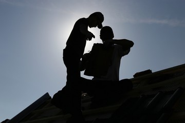 Silhouette eines Dachdeckers im Gegenlicht