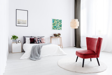 Red armchair in white bedroom
