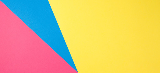 Color papers geometry flat composition background with yellow, pink and blue tones