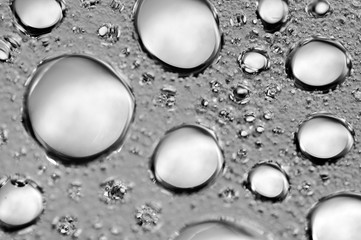 Black-and-white background with big and small grey bubbles inside a gray liquid.