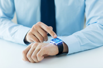 Obraz premium business, technology and cryptocurrency concept - close up of male hand wearing smart watch with bitcoin on screen