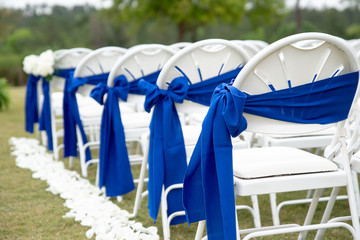Fototapeta na wymiar white wedding ceremony chairs with blue bows