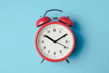 Fotobehang Red vintage alarm clock on light blue color background © samrit